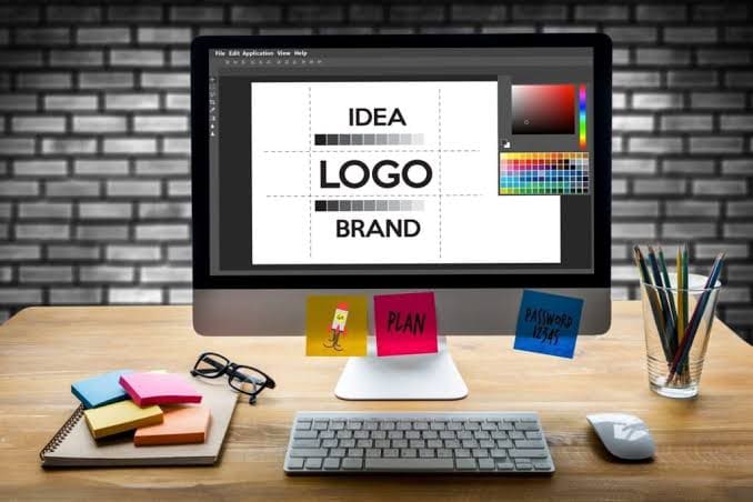Designer sketching a logo concept on a desktop monitor
