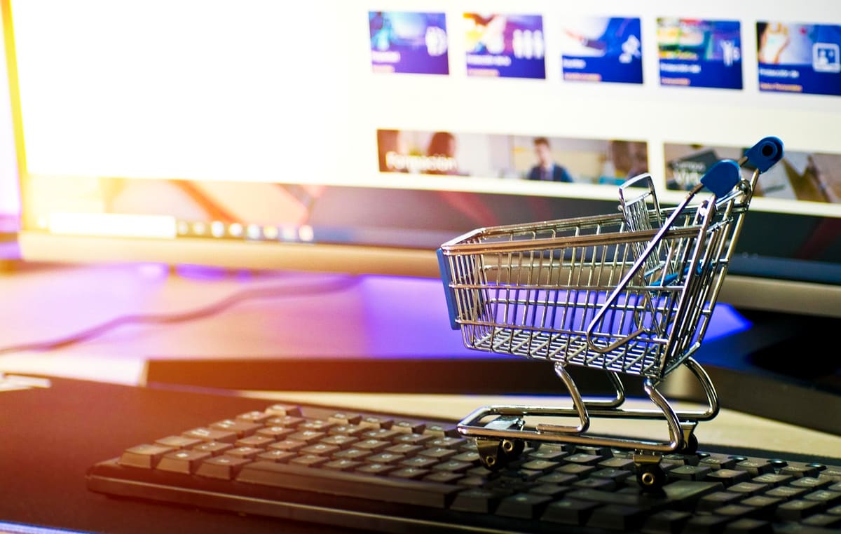 Miniature shopping cart on a keyboard in front of an online storefront
